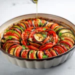 Ratatouille façon Confit Byaldi avec des légumes en fines rondelles disposées en spirale, illustrant une alternative à la recette ratatouille classique.