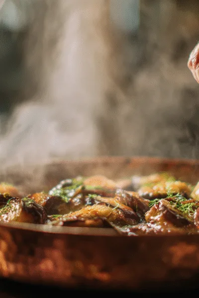 Cuisson traditionnelle des dés d'aubergines dans une sauteuse pour la préparation de la caponata.