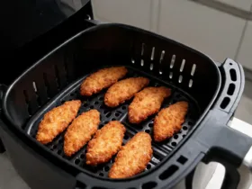 Aiguillettes de poulet airfryer dorées disposées en une seule couche dans le panier
