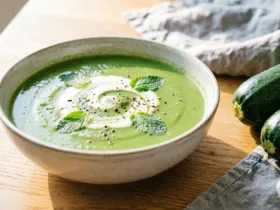 Velouté de courgettes Thermomix vert vif dans un bol en grès, menthe et poivre