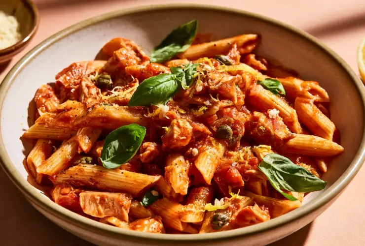 Plat de pâtes au thon à la sauce tomate, câpres, zeste de citron et basilic frais